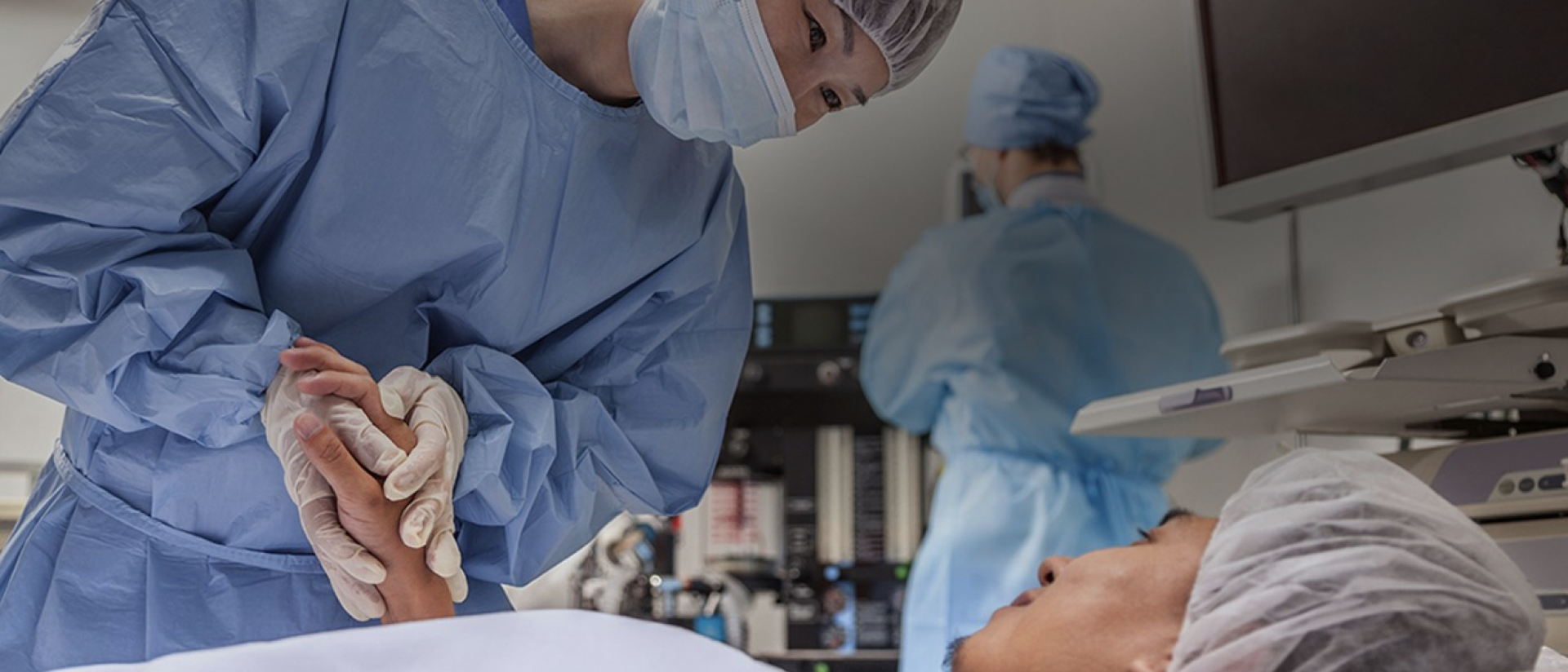 um grupo de pessoas com jalecos azuis e máscaras