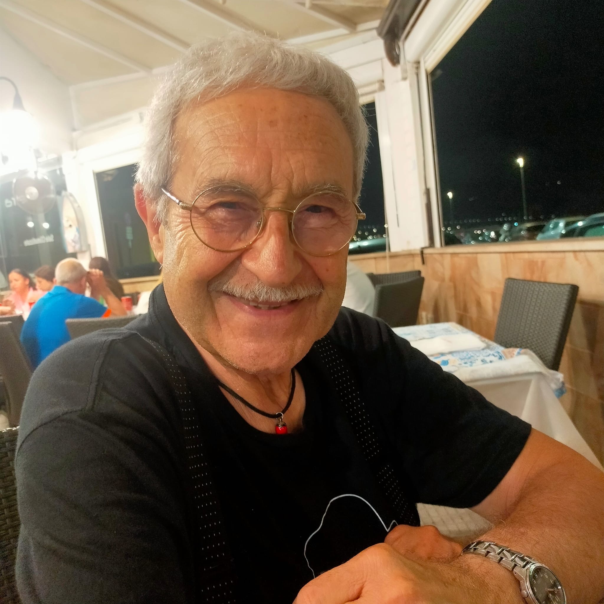 a man with glasses smiling