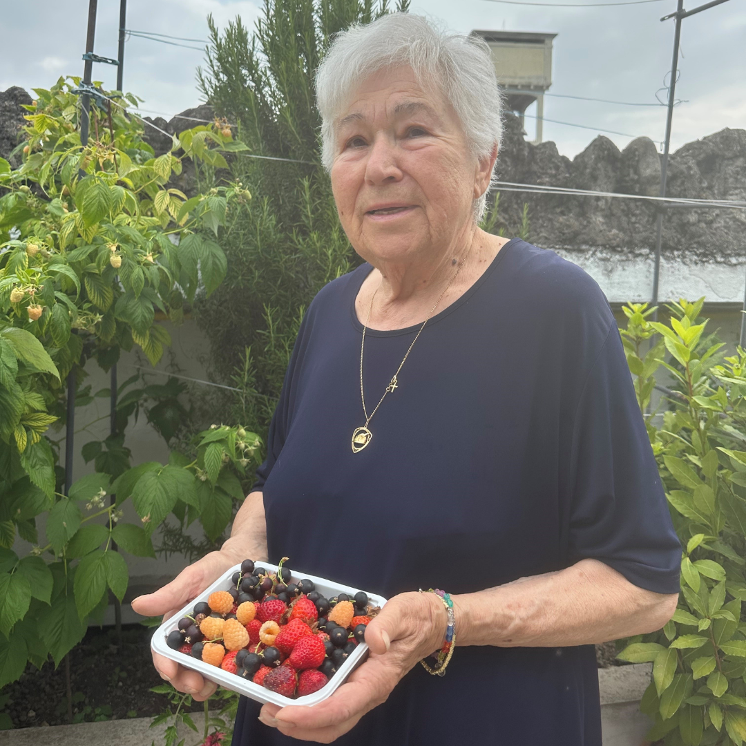 a person holding a tray of strawberries