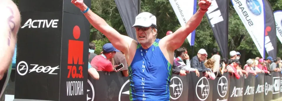 a man wearing a blue shirt and white hat with his arms raised