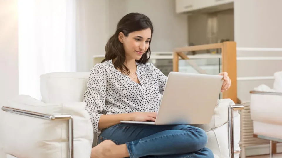 a woman sitting in a chair using a laptop
